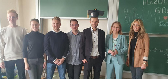 2022 Dr. Marius Banke Foto von Doktor Marius Banke unmittelbar nach seiner Promotion, im Kreise seiner Kolleg*innen aus dem IRWP-Team